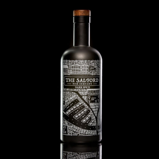 Front view of Salford Dark Spice Rum matte black glass bottle with silver map design and wooden stopper on a dark reflective surface.